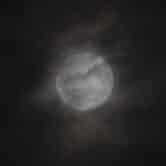 A penumbral lunar eclipse is partially obscured by clouds.
