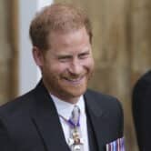 Prince Harry smiles while wearing a suit.