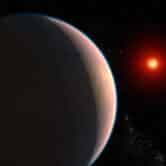 a red planet in space with a star in the distant background