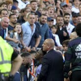 Valencia fans look at Vinícius Júnior as he exits a La Liga match at Mestalla Stadium.