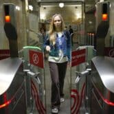 A woman walks through glass doors as they open in a Moscow subway station.
