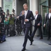 Prince Harry waves while walking members of the media after exiting the High Court in London.