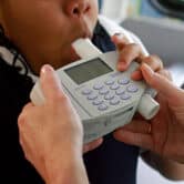 A Black child blows into a spirometer.