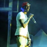 Young Dolph holds a microphone near his face while performing at The Parking Lot Concert in Atlanta.