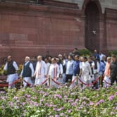 Narendra Modi and more than two dozen other Indian lawmakers walk in a precession outside the Parliament building.