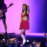 Crowd members raise their arms as Olivia Rodrigo performs on stage at the 2023 MTV Video Music Awards.