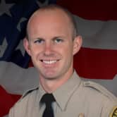 Ryan Clinkunbroomer poses for a photo in his sheriff's department uniform.