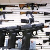 Assault weapons and hand guns displayed on a wall and counter
