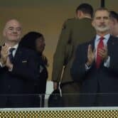 Gianni Infantino, left, and King Felipe VI, right, clap while standing in a stadium suite.