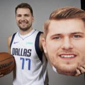 Luka Dončić poses for a photo while holding a basketball and a cardboard cut-out of his head.