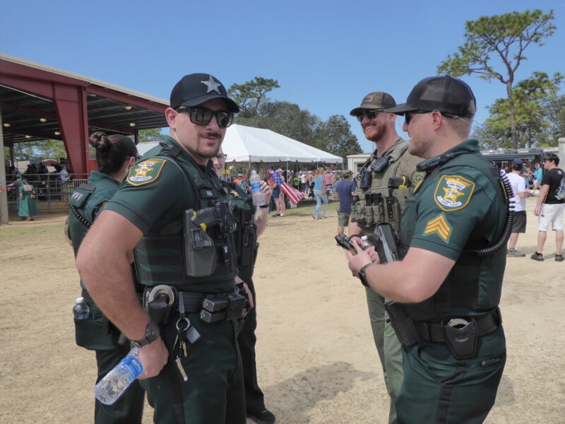 Four police officers in full uniform at the county fairgrounds.
