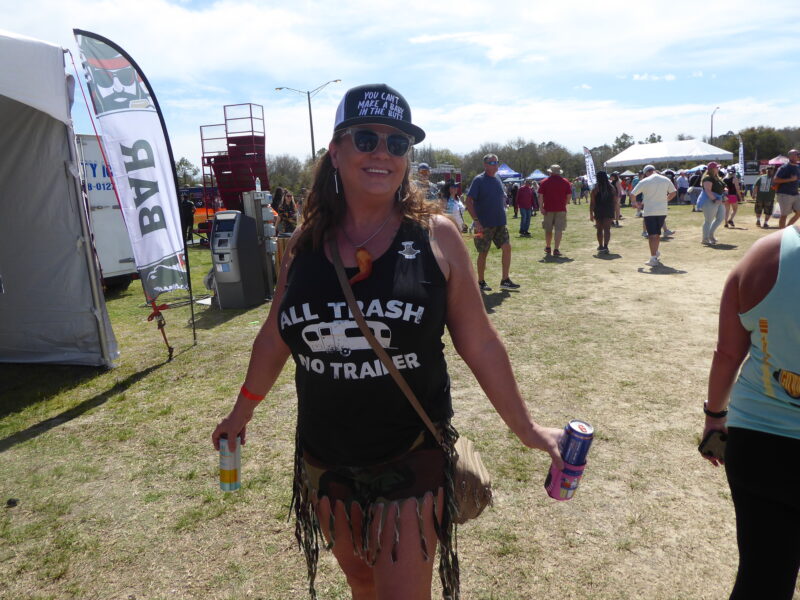 A woman in shorts and tank top and carrying two beers