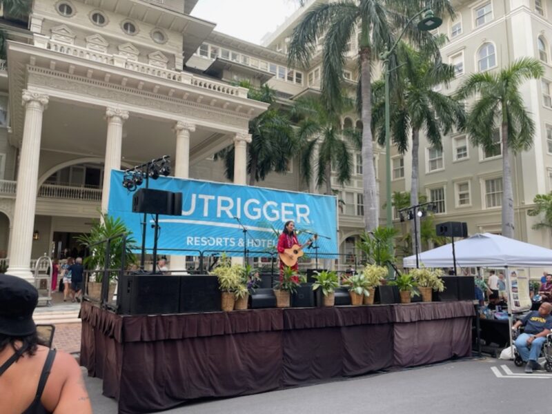 Woman playing guitar on stage at Hawaii's Spam Jam.