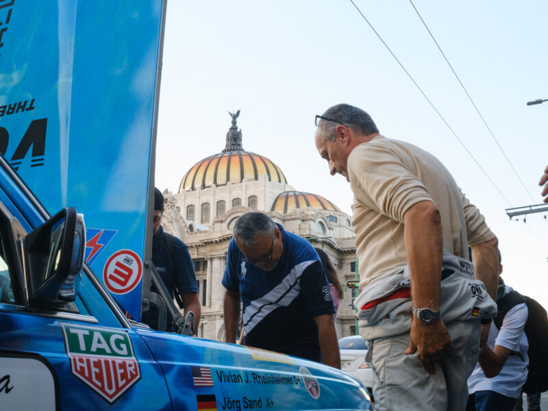 Two men assess a broken down car in front of Bellas Artes in Mexico City.