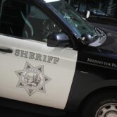 Close-up of a San Diego County Sheriff’s patrol vehicle showing the sheriff’s star emblem on the door.