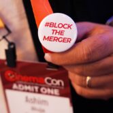 Conference attendee wears anti-merger button