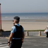 Police officers patrol near beach shoreline