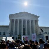 Protesters holding anti-Monsanto signs gather outside the U.S. Supreme Court