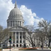 The Wisconsin State Capitol building in Madison, featuring a large white dome topped with a statue.