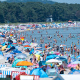 Crowds of beachgoers gather along the shoreline on Germany's Rügen island during a European heat wave.
