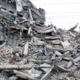 A man walks through the rubble of a collapsed apartment building after earthquakes in La Guaira, Venezuela.