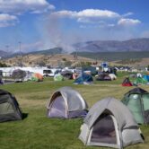 Wildfire smoke rises beyond campground tents
