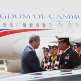 Cambodian Prime Minister Hun Manet greets a military official beside a Cambodian government aircraft during his arrival in the Philippines.