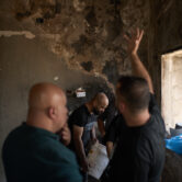 Palestinians inspect and repair the interior of a fire-damaged home following an attack by Israeli settlers in the West Bank village of Sarra.