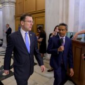 Rep. Tom Kean Jr. walks through the U.S. Capitol as a reporter interviews him before a House vote.