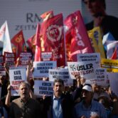 Protesters wave flags and hold anti-NATO signs during a demonstration in Istanbul ahead of the NATO summit.