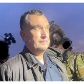 The man convicted of killing a Minnesota lawmaker stands with two troops in camouflage.
