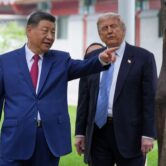 Chinese President Xi Jinping walks beside President Donald Trump through the Zhongnanhai leadership compound in Beijing, gesturing ahead during a meeting.